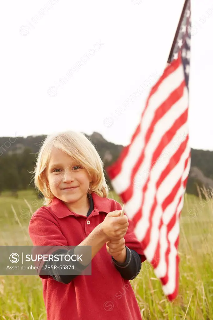 Portrait of boy 6_7 waving American flag