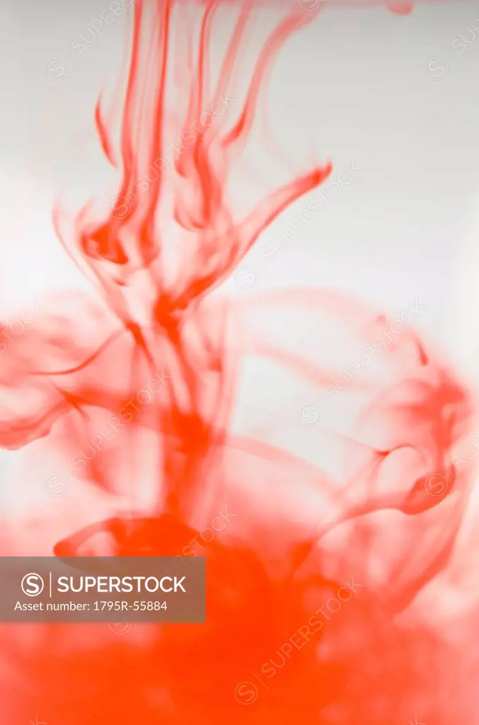 Studio shot of red liquid dissolving in water