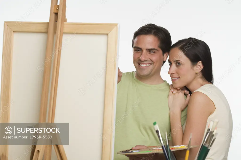 Couple smiling and looking at easel