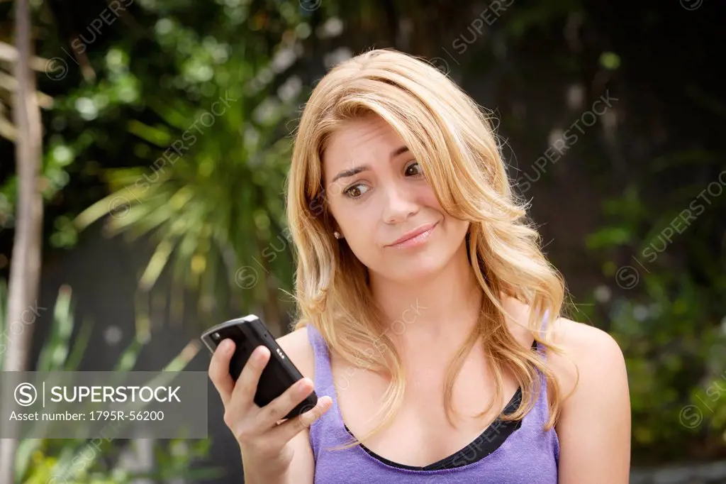 Young woman text_messaging, with facial expression