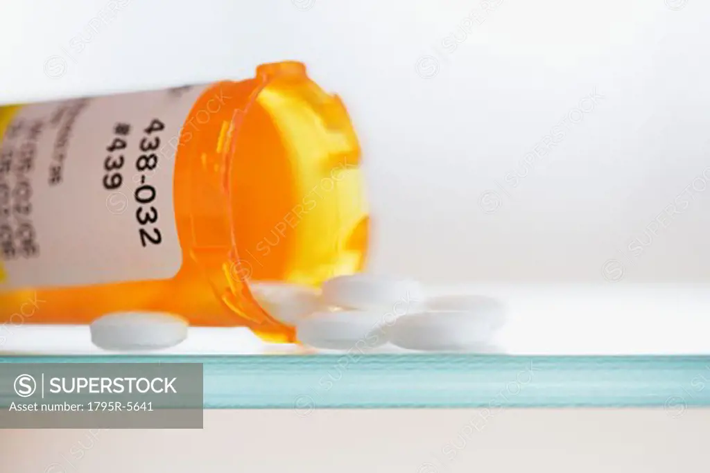 Close-up of pills spilling out of medication bottle