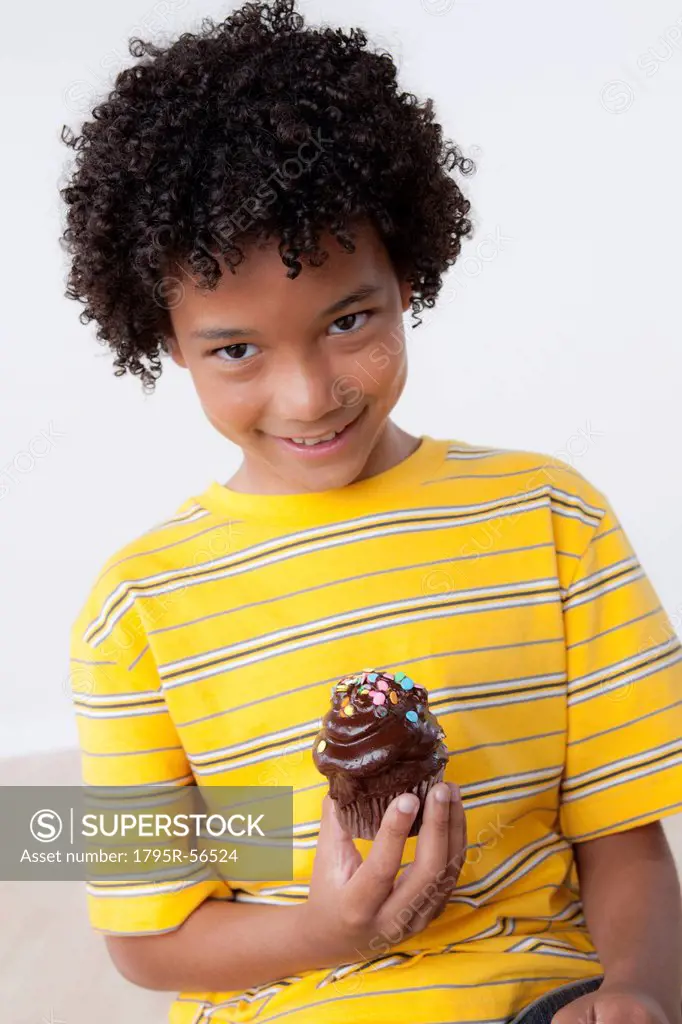 Studio portrait of boy 8_9 holding muffin