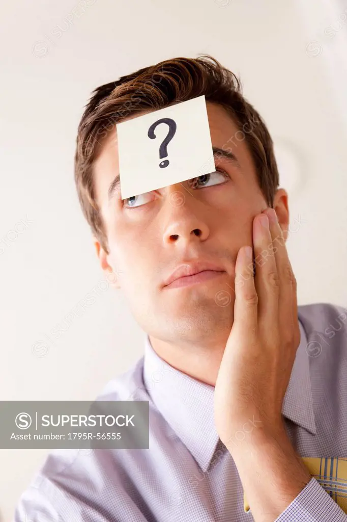 Portrait of businessman with adhesive note attached on forehead
