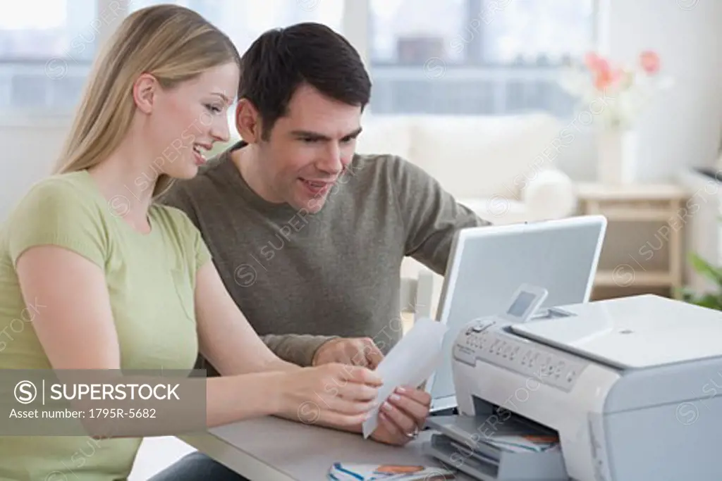 Couple printing picture with laptop
