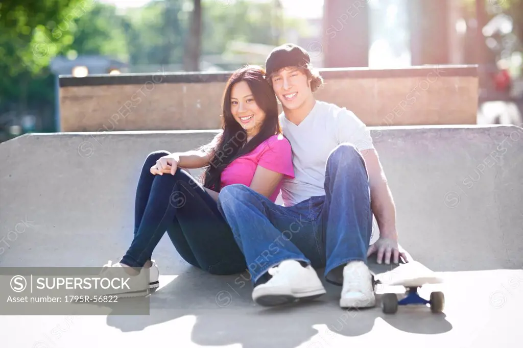 Young multi_racial couple posing with skateboard