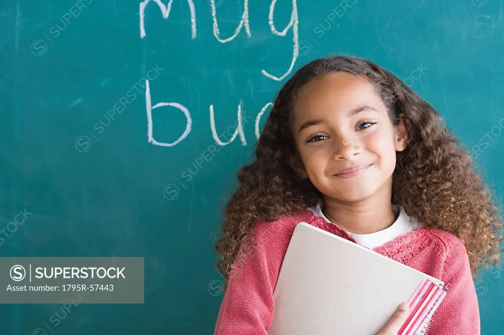 Smiling girl 6_7 against blackboard