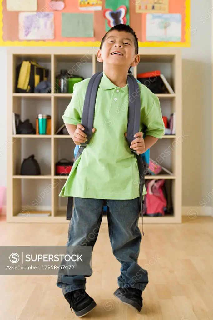 Boy 6_7 holding backpack and laughing