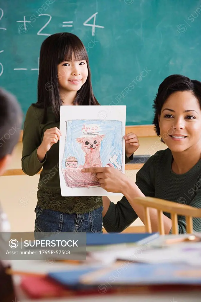 Girl 6_7 showing her drawing in classroom