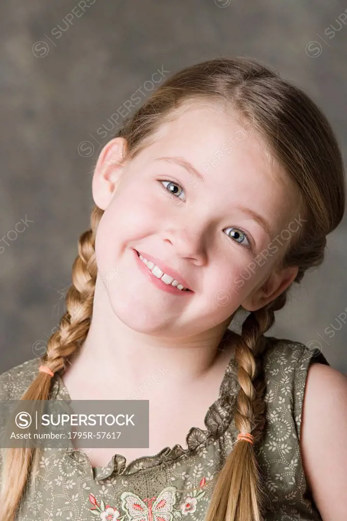 Portrait of smiling girl 8_9 with braids, studio shot