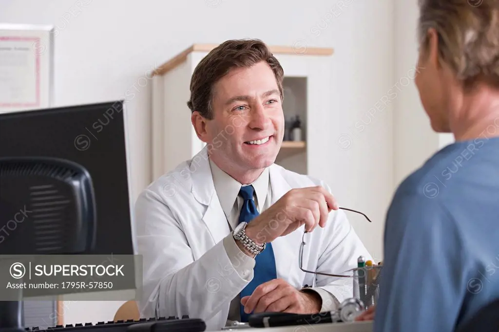 Male doctor talking to patient in his office