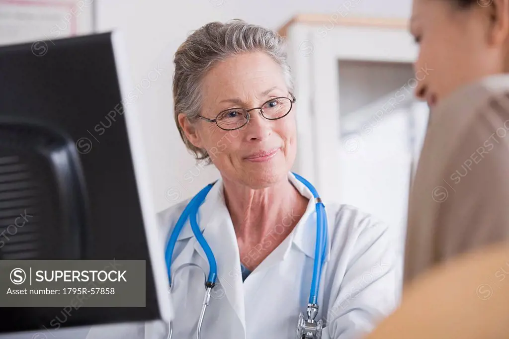 Smiling female doctor talking to patient in her office