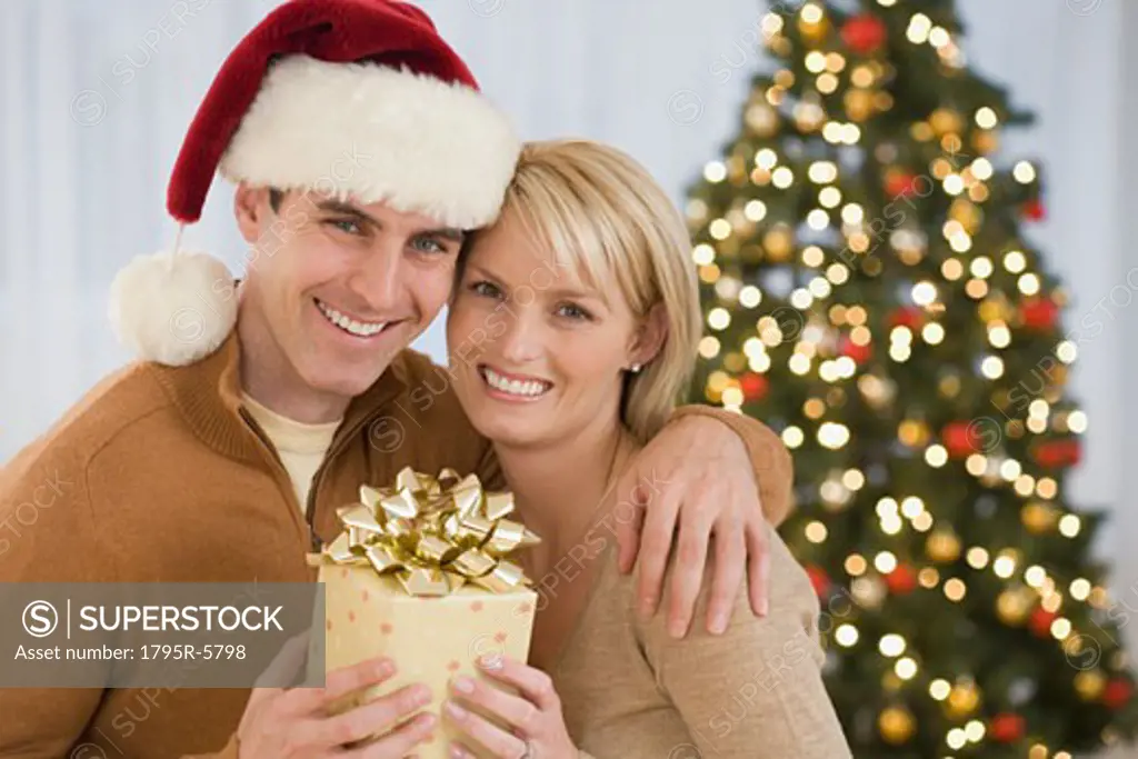 Portrait of couple holding Christmas gift