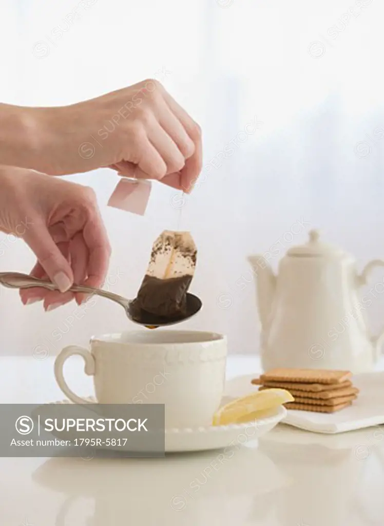 Woman taking tea bag out of cup