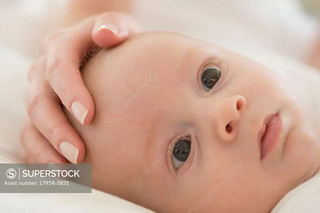 Close-up of mother's hand on baby's head