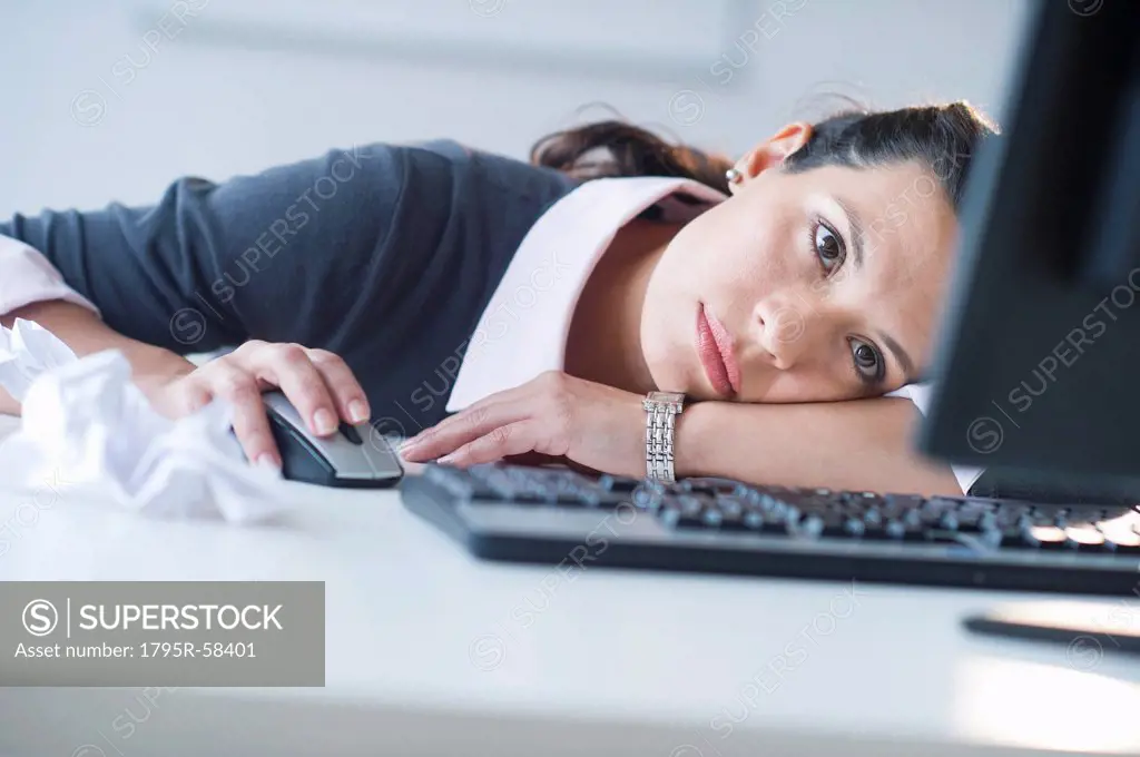 Businesswoman in front of computer, looking tired