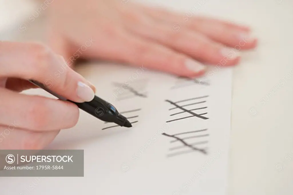 Close-up of woman counting on paper