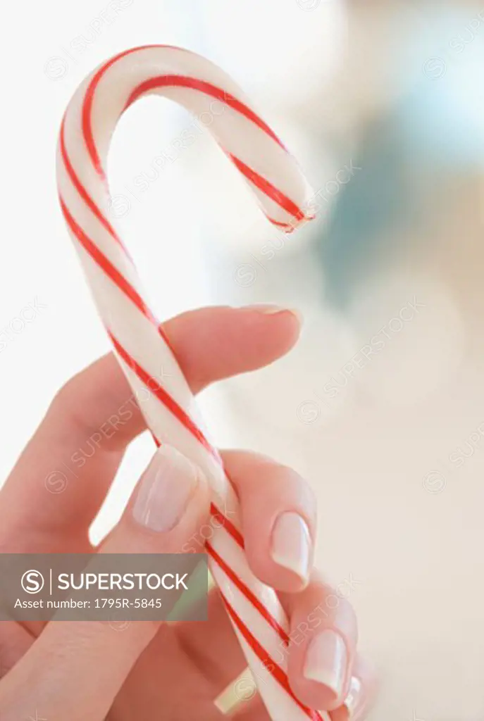 Close-up of woman holding candy cane
