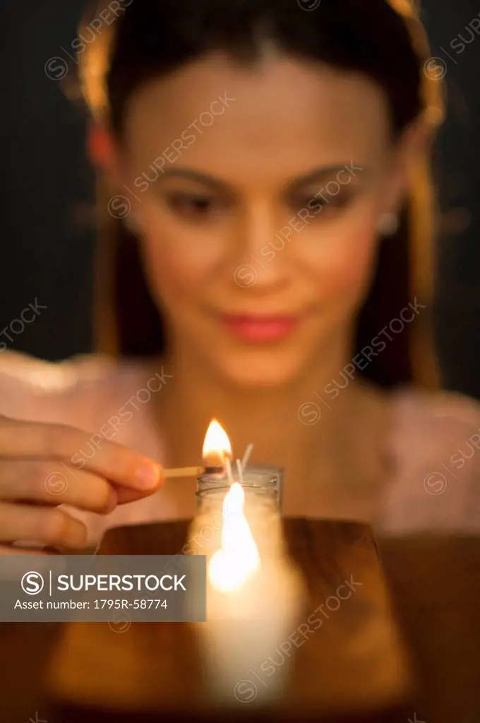 Woman igniting candle