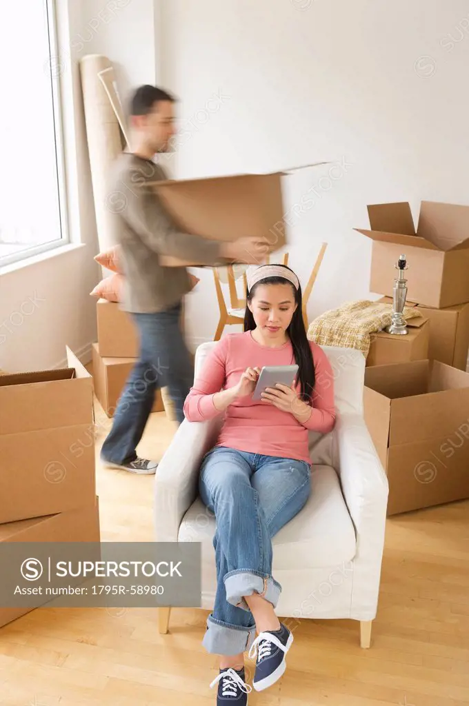 Man and woman unpacking things in new house