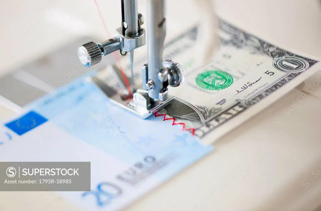 Halves of banknotes being sewed with sewing machine