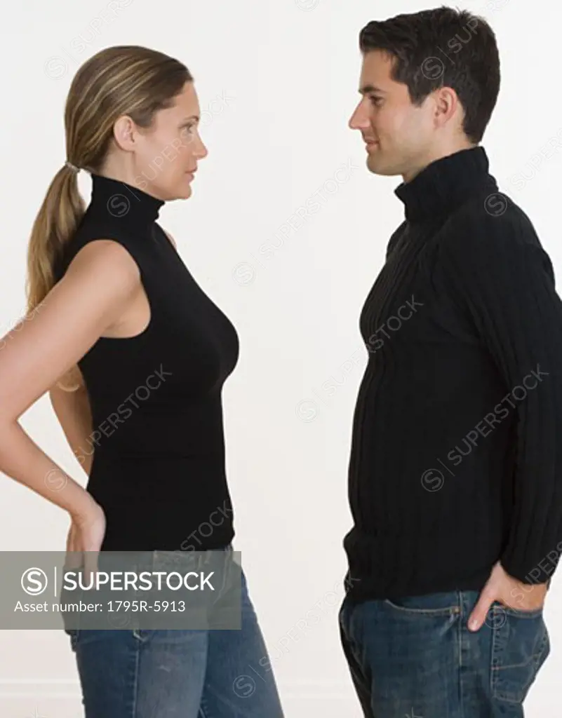 Studio shot of couple with hands in back pockets