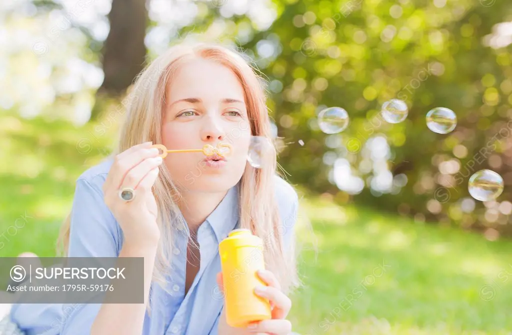 USA, New York, New York City, Manhattan, Central Park, Woman blowing bubbles