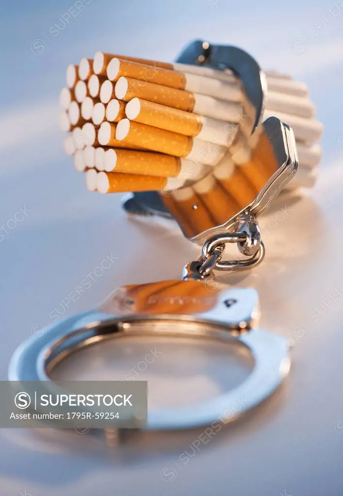 Close up of bunch of cigarettes locked in handcuffs