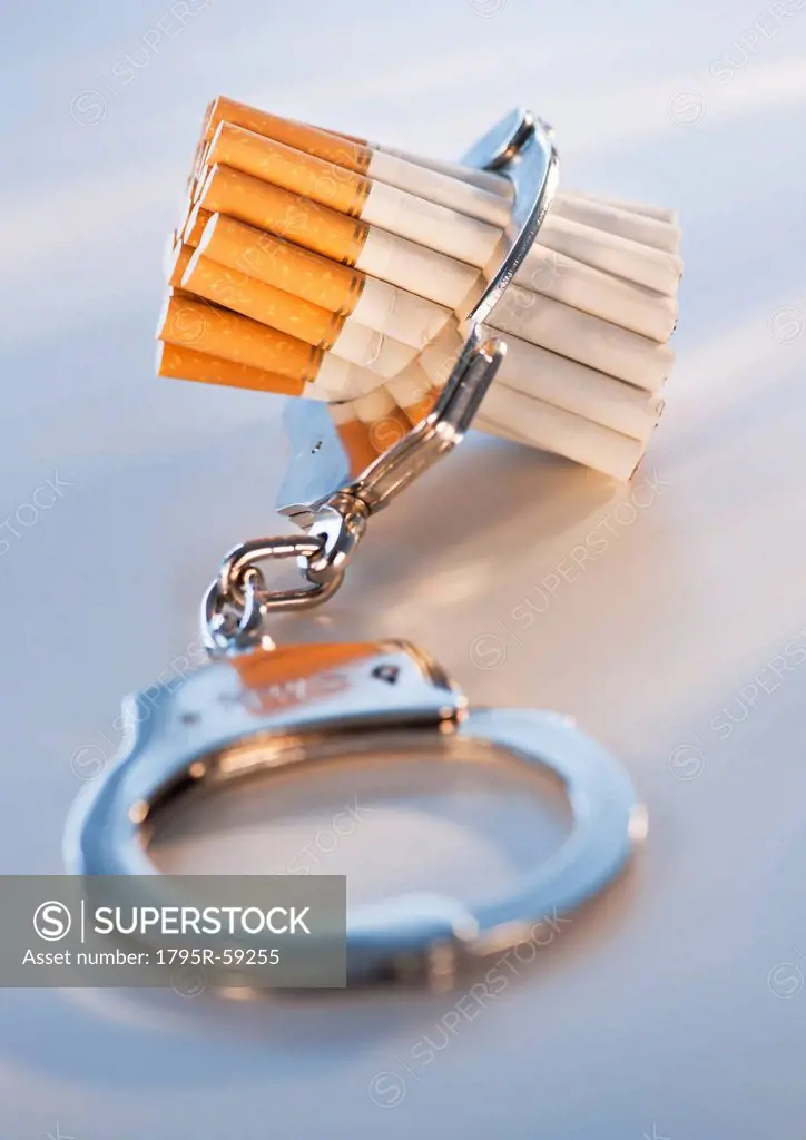 Close up of bunch of cigarettes locked in handcuffs