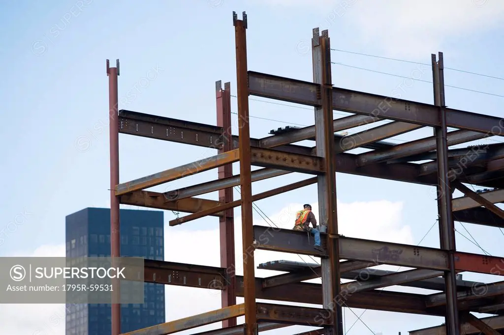 USA, New York City, Construction worker sitting on unfinished structure