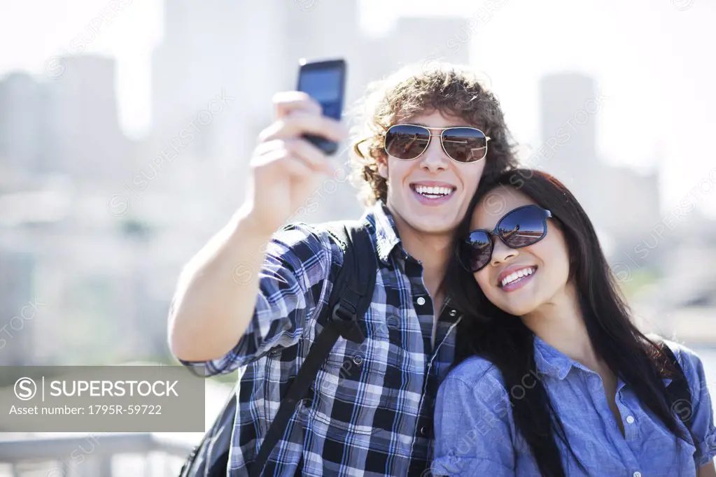 USA, Washington, Seattle, Couple wearing sunglasses photographing themselves with smart phone
