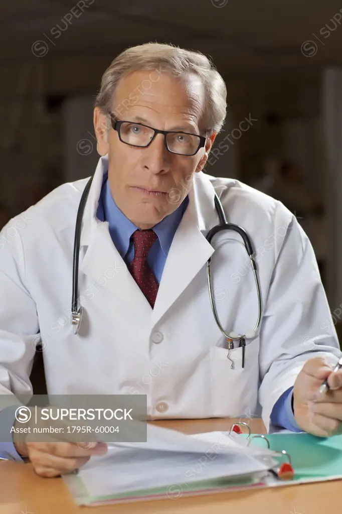Portrait of male doctor reading files