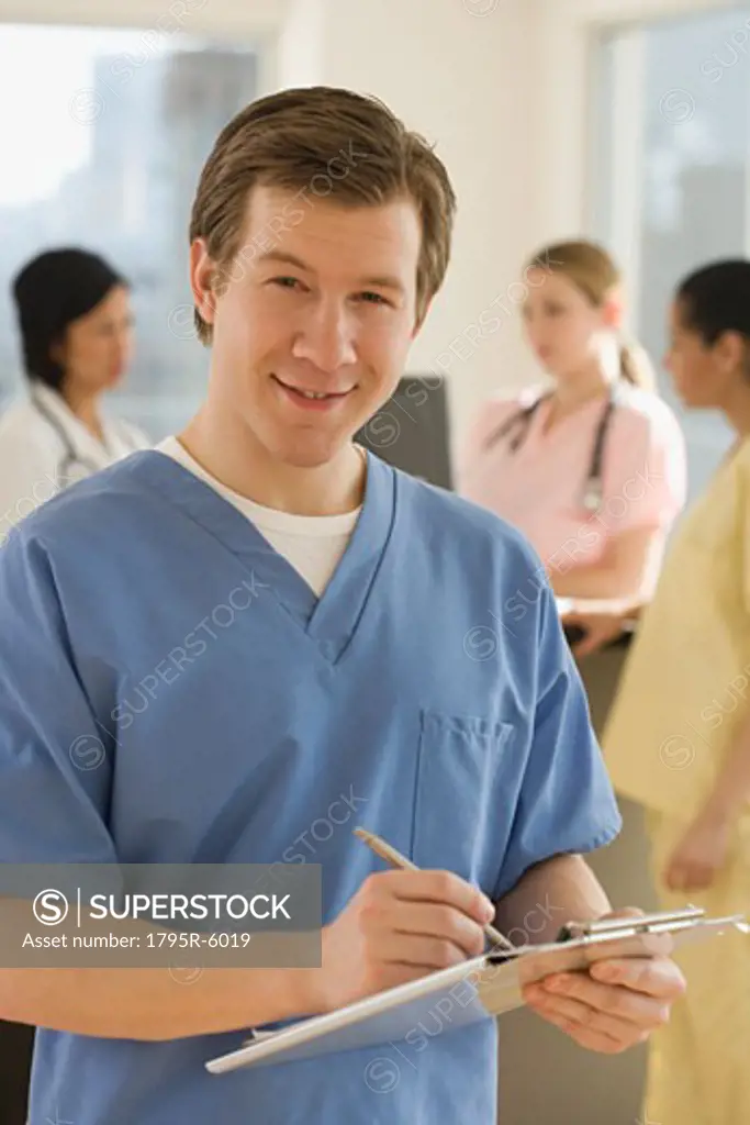 Portrait of male doctor writing on chart