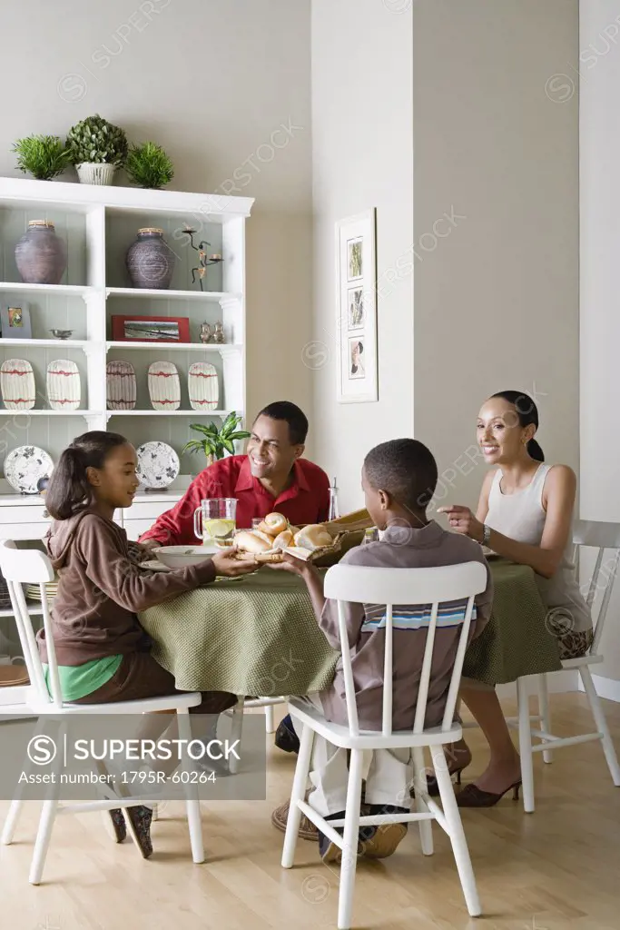 Parents and children (10-13) eating dinner together