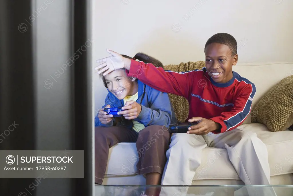 Brother and sister (10-13) playing video game