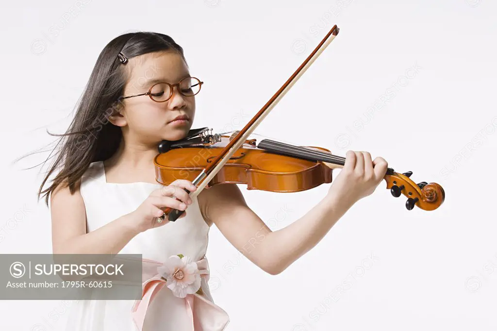 Studio portrait of girl (8-9) playing violin