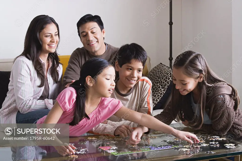 Family with three children (8-9, 10-11) playing with puzzle