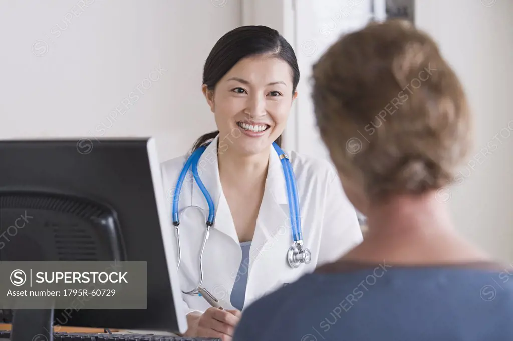Smiling female doctor talking to patient in her office