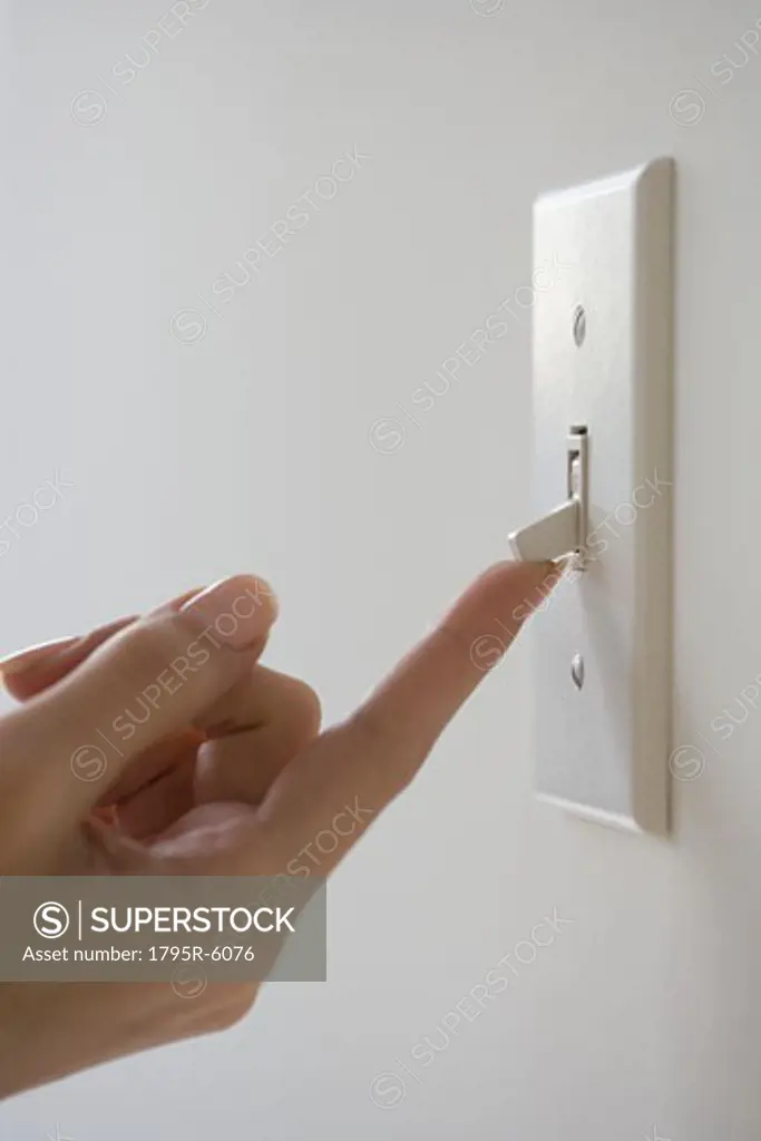 Close-up of woman turning on light switch
