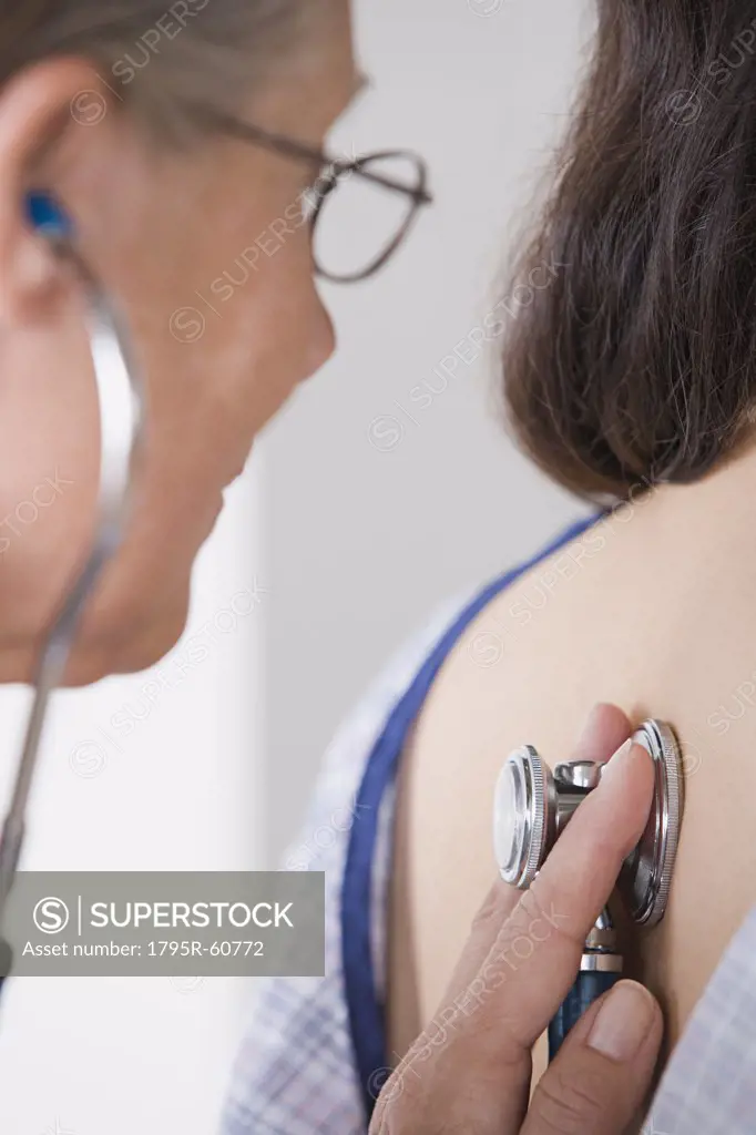 Close-up of female doctor examining patient with stethoscope