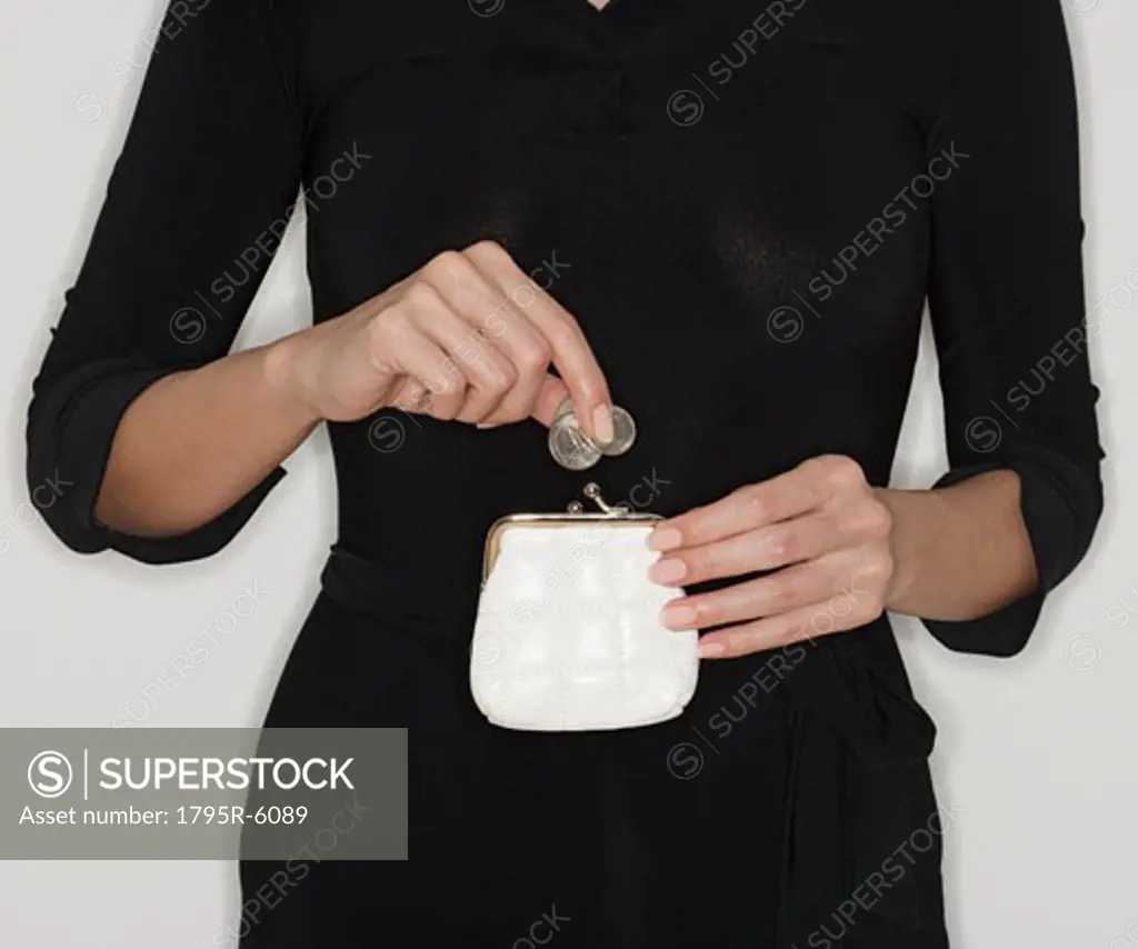 Woman dropping coins in purse