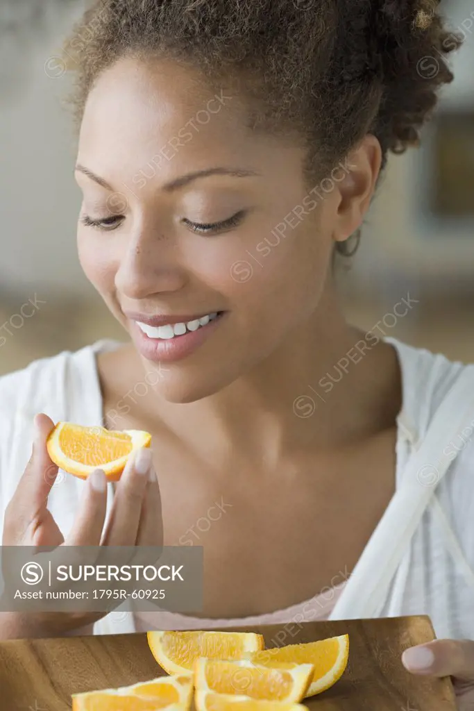 Portrait of attractive woman eating orange