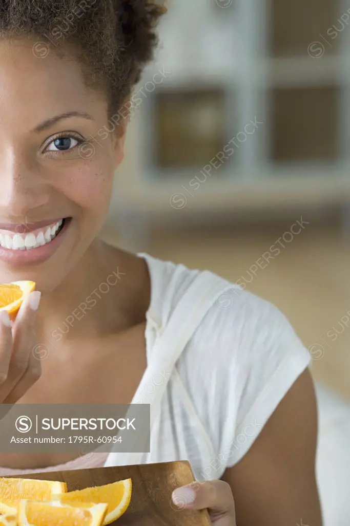 Attractive woman eating orange