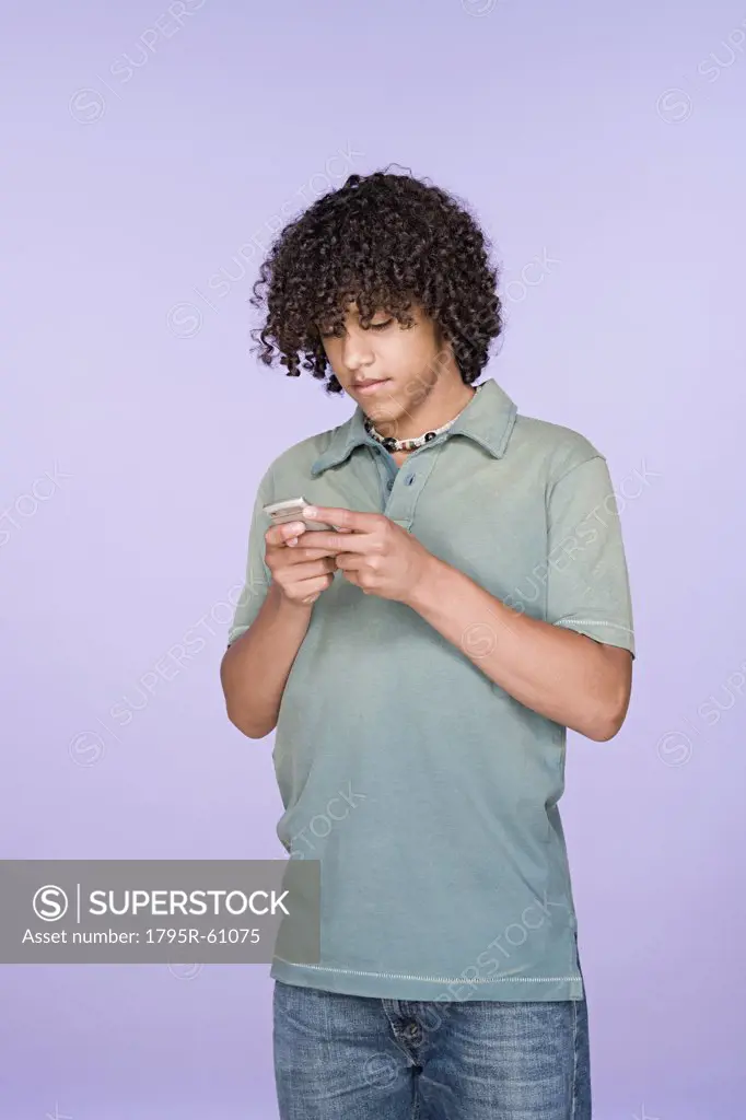 Portrait of teenage boy (14-15) texting on mobile phone