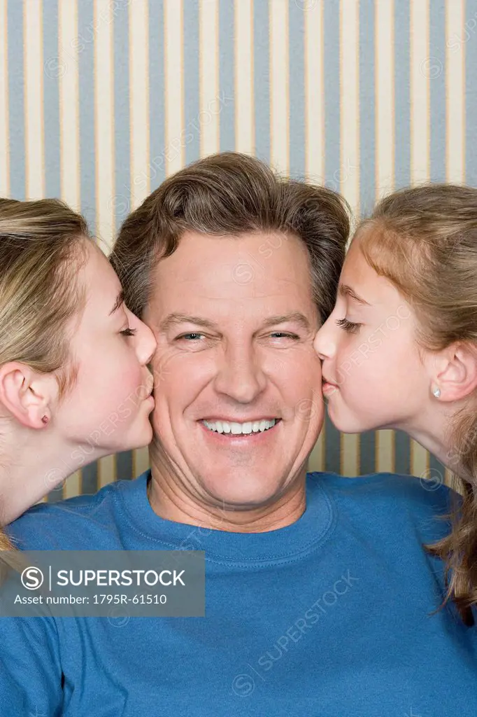 Portrait of father being kissed by two girls 8_9, 14_15