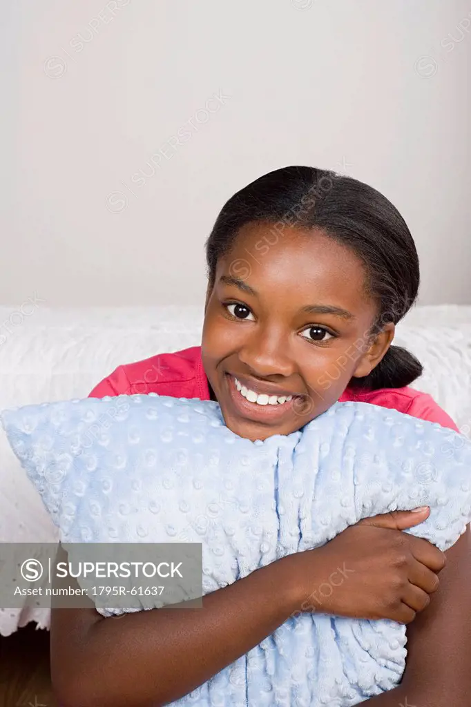 Portrait of smiling girl 10_11 with pillow