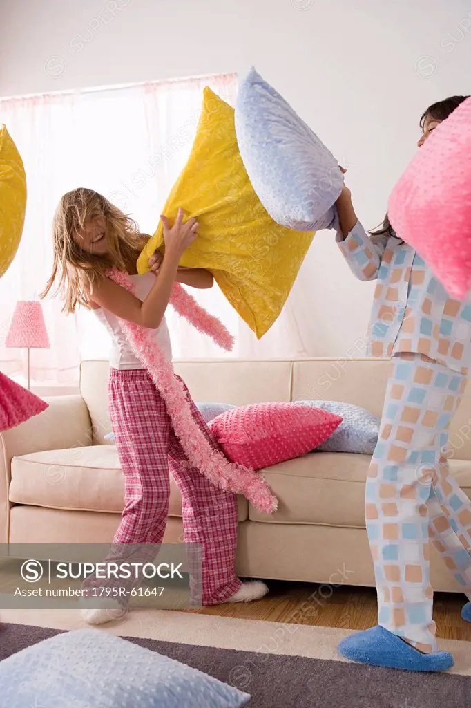 Two girls 10_11 having pillow fight at slumber party