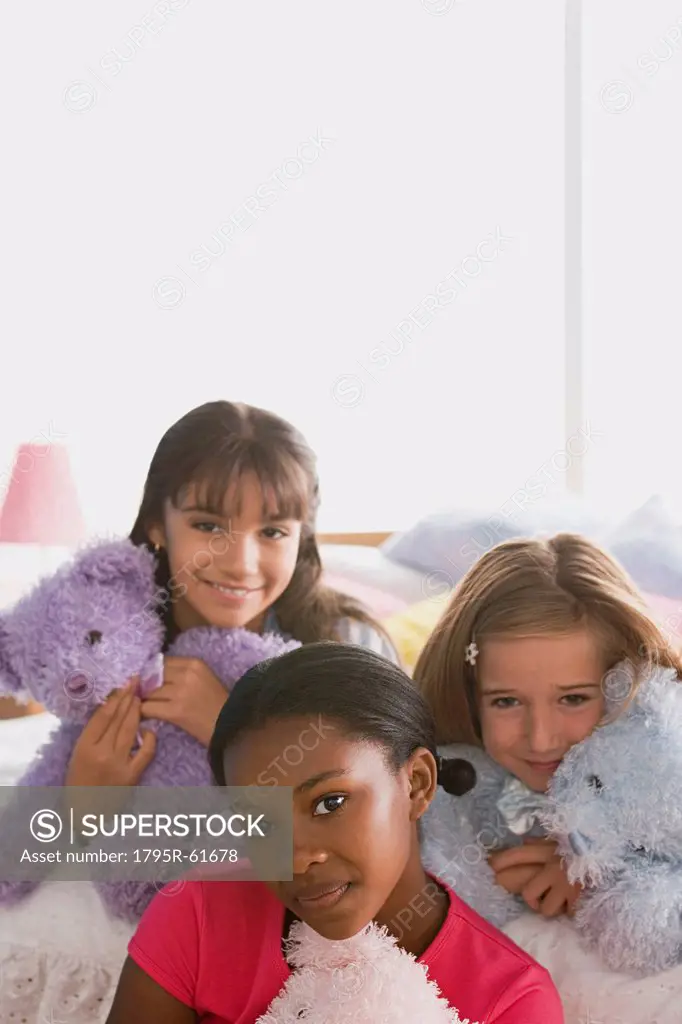 Portrait of three girls 10_11 with puppets in bed