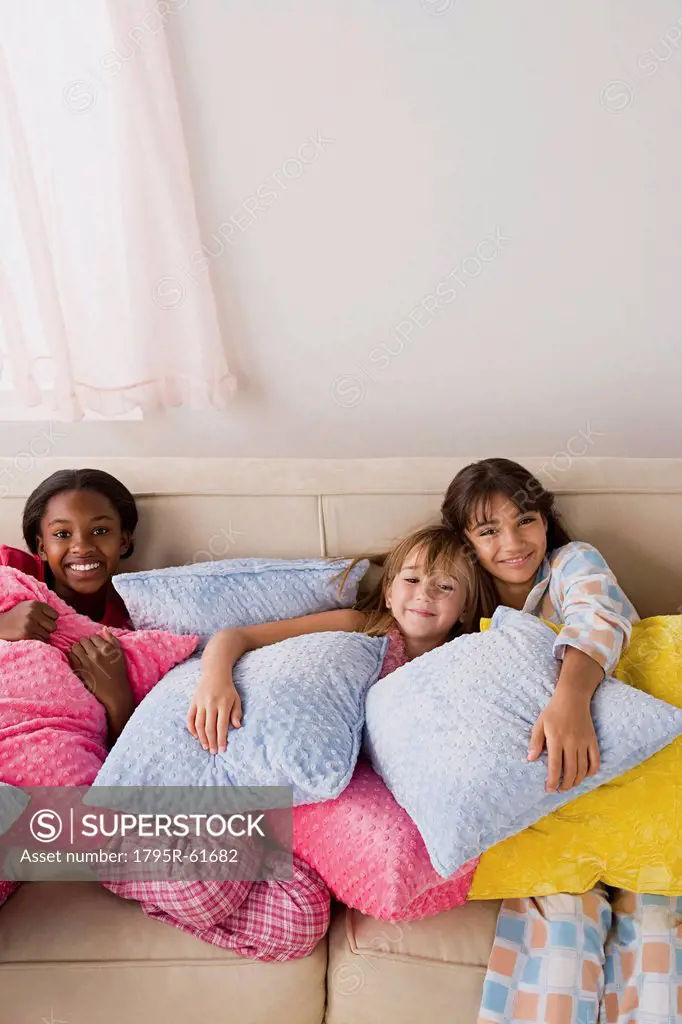 Portrait of three girls 10_11 lying on sofa at slumber party
