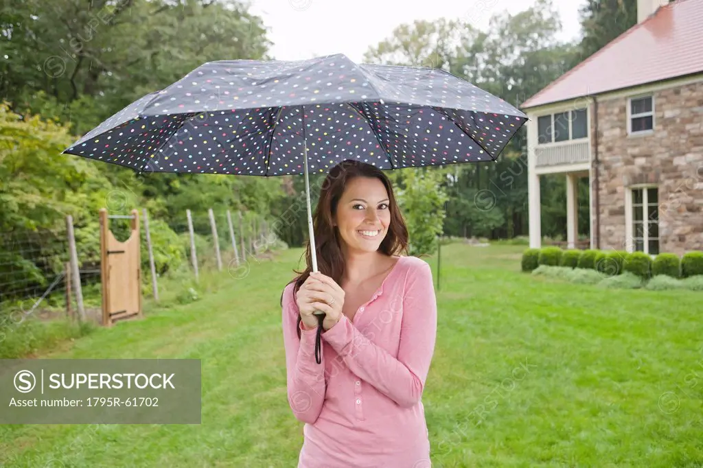 USA, New Jersey, Portrait of woman holding umbrella