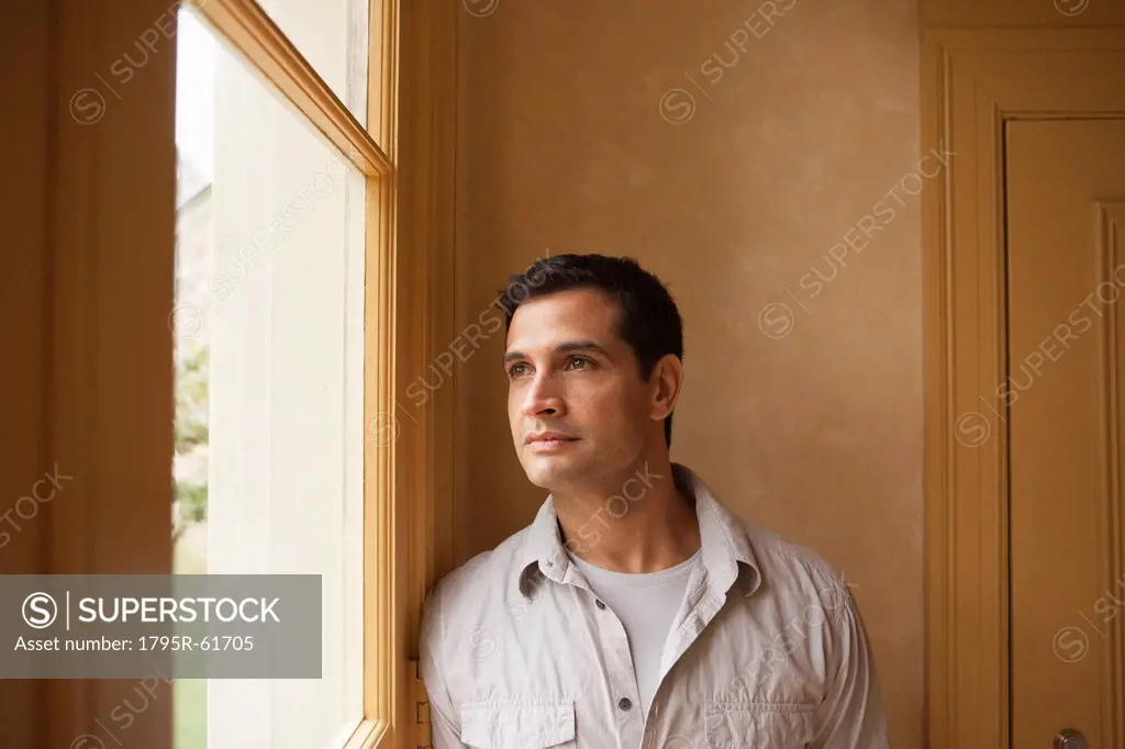 Portrait of man looking out window